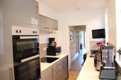 a kitchen with a black stove top oven next to a counter at King-size 3Bed House in Leicester in Leicester