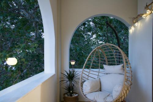 a wicker chair in a room with a window at Platani Seaside Villa in Sitia
