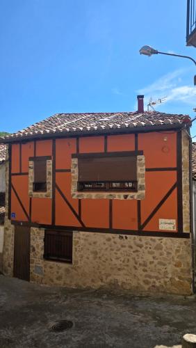 an orange building with a window on the side of it at La herradura, acogedora casa en Montemayor del Río in Montemayor del Río