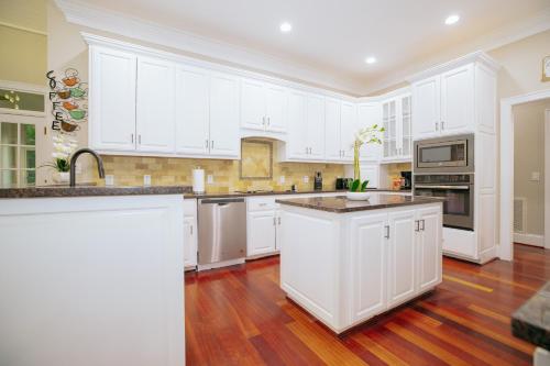 a kitchen with white cabinets and a wooden floor at Beautiful Estate in 19 acres of land in Apex in Apex