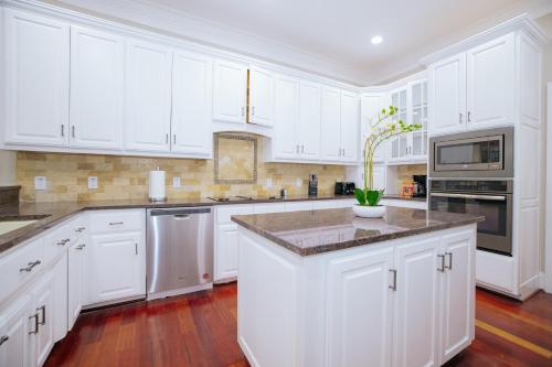 a white kitchen with white cabinets and a counter top at Beautiful Estate in 19 acres of land in Apex in Apex