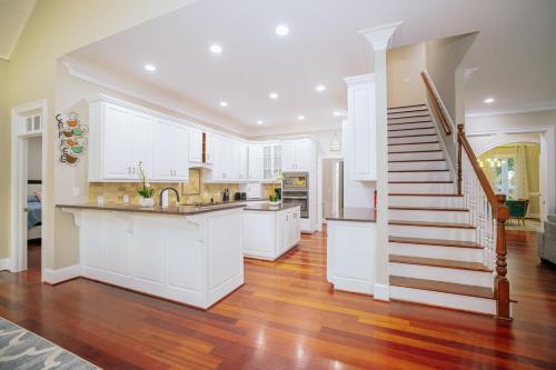 a kitchen with white cabinets and a staircase at Beautiful Estate in 19 acres of land in Apex in Apex