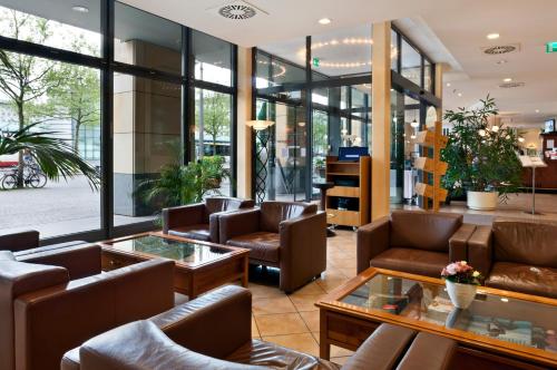 a lobby with couches and tables and windows at IntercityHotel Bremen in Bremen