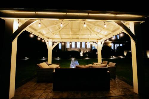 a pergola with couches on a patio at night at Beautiful Estate in 19 acres of land in Apex in Apex