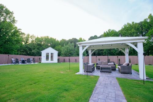 a white pavilion in a yard with chairs and tables at Beautiful Estate in 19 acres of land in Apex in Apex