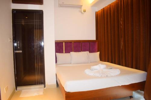 a bedroom with a bed with a wooden headboard at Needs Bay Watch in Cox's Bazar