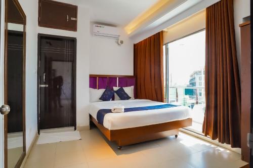 a bedroom with a bed and a large window at Needs Bay Watch in Cox's Bazar