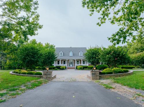 a driveway leading to a large white house at Beautiful Estate in 19 acres of land in Apex in Apex