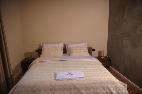 a bedroom with a bed with a towel on it at Greco Boutique Hotel in Shkodër