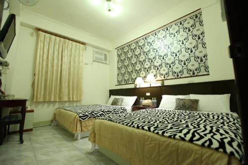 a bedroom with two beds and a desk and a wall at Relax heart B&B in Dongshan