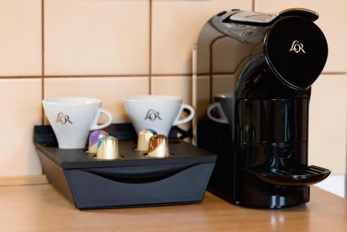 a coffee maker sitting on a counter with two cups at Apartmány Bramborka in Janov nad Nisou