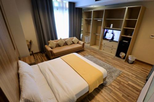 a bedroom with a bed and a couch and a television at Farida Habu Palace Hotel luxor in Al Aqālitah