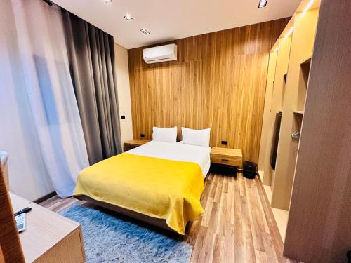 a hotel room with a bed with a yellow blanket at Farida Habu Palace Hotel luxor in Al Aqālitah