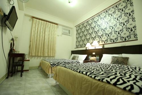 a hotel room with two beds and a tv at Relax heart B&B in Dongshan