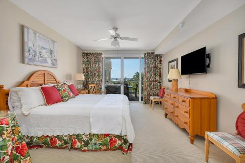 Un dormitorio con una cama y un televisor de pantalla plana. en St. Simons Grand #219, en Saint Simons Island