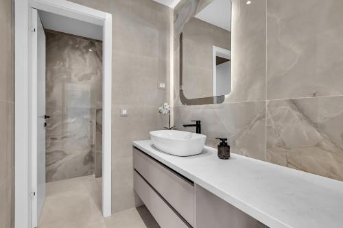 a white bathroom with a sink and a mirror at Blue Dream - La Luna Residence in Tučepi