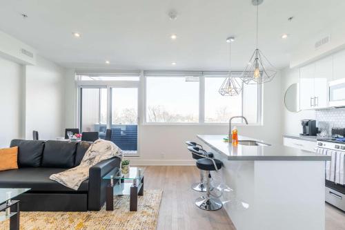 a kitchen and living room with a couch and a table at Bright & Inviting 3BR Apartment near High Park Nearest Intersection Indian Trail in Toronto