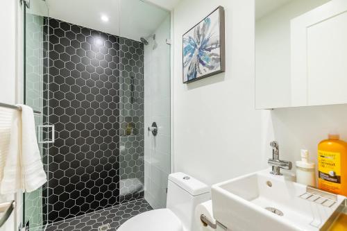 a bathroom with a shower and a toilet and a sink at Bright & Inviting 3BR Apartment near High Park Nearest Intersection Indian Trail in Toronto