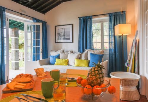 een woonkamer met een bank en een tafel met fruit erop bij Oceanfront Casa do Mirante in Ponta Delgada