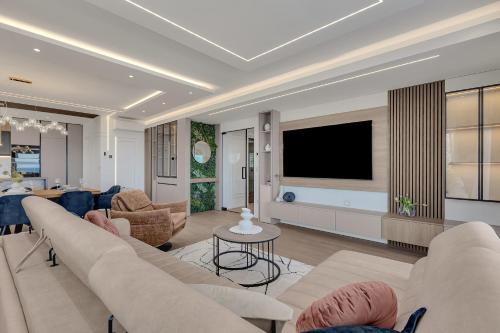 a living room with a couch and a tv at Blue Dream - La Luna Residence in Tučepi