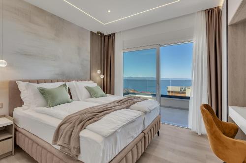 a bedroom with a large bed and a large window at Blue Dream - La Luna Residence in Tučepi