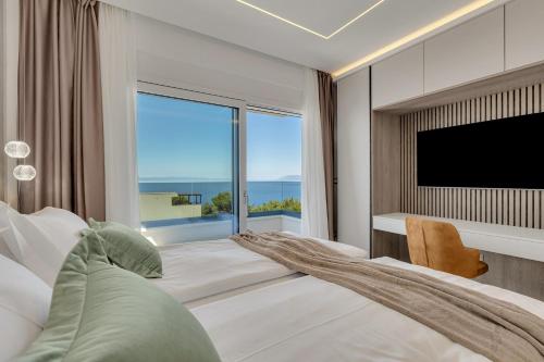 a bedroom with a large window and a television at Blue Dream - La Luna Residence in Tučepi
