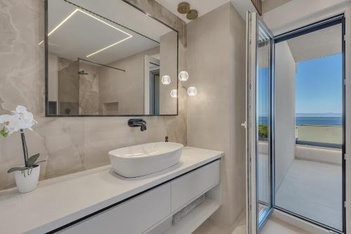 a bathroom with a white sink and a glass shower at Blue Dream - La Luna Residence in Tučepi