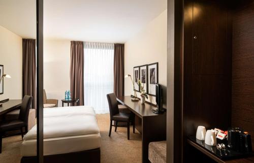a hotel room with a bed and a desk at The Rilano Hotel München in Munich