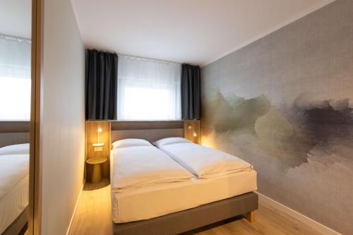 a bedroom with a bed and a painting on the wall at The Rilano Hotel München in Munich