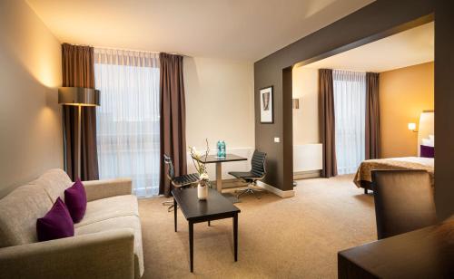 a hotel room with a couch and a table at The Rilano Hotel München in Munich