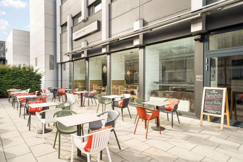 a patio with tables and chairs in front of a building at The Rilano Hotel München in Munich