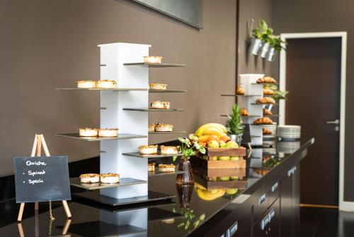 a display of cupcakes and other desserts on shelves at The Rilano Hotel München in Munich