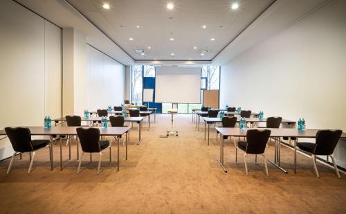 a conference room with tables and chairs and a whiteboard at The Rilano Hotel München in Munich