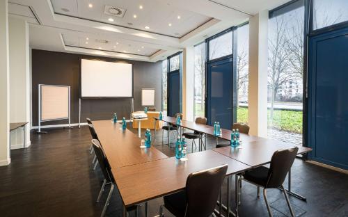 a conference room with a long table and chairs at The Rilano Hotel München in Munich