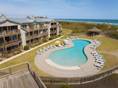 an aerial view of a pool with chairs and the ocean at The Sanderling in Duck