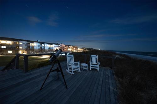 a camera on a tripod with two chairs on a deck at The Sanderling in Duck