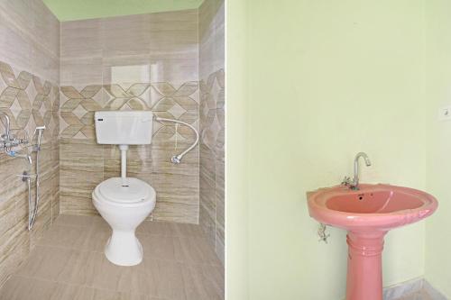 a bathroom with a pink sink and a toilet at Hotel O Ss Delight in Hyderabad
