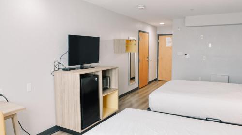 a bedroom with a bed and a tv on a cabinet at Microtel Inn & Suites by Wyndham Gulf Shores in Gulf Shores