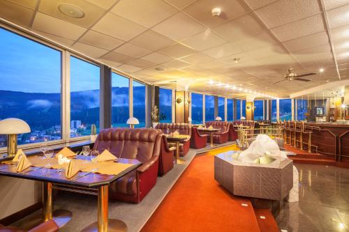a restaurant with tables and chairs and large windows at Hotel Horizont in Pec pod Sněžkou