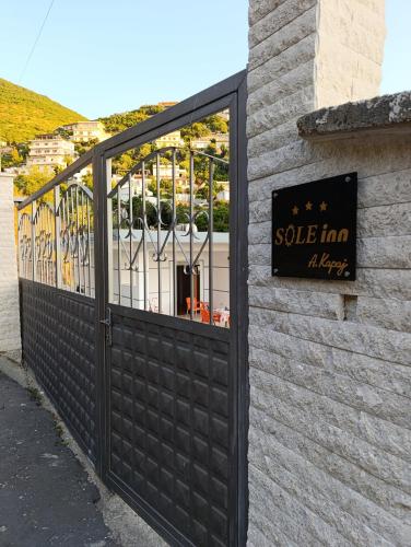 a black gate with a sign on the side of a building at SOLE INN in Vlorë