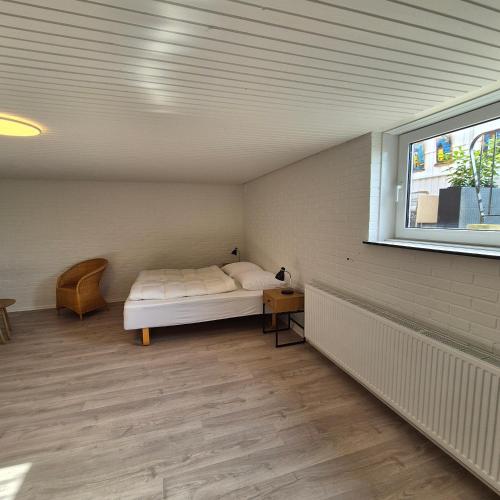 a bedroom with a bed and a window at Feriehuse Hvide Sande in Hvide Sande