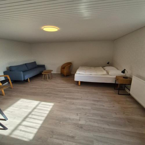a bedroom with a bed and a couch in a room at Feriehuse Hvide Sande in Hvide Sande