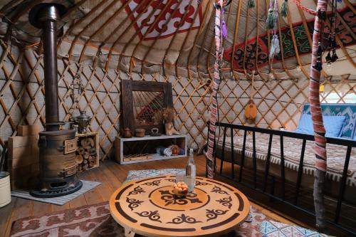 a room in a yurt with a table in it at Family Eco Farm Getaway in Ryskulovo