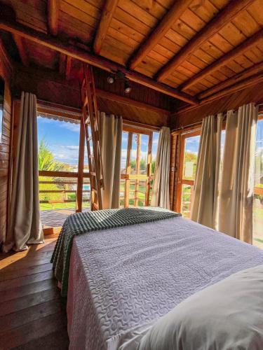 a bedroom with a bed in a room with windows at Pousada La Belle de Jour in Majorlândia