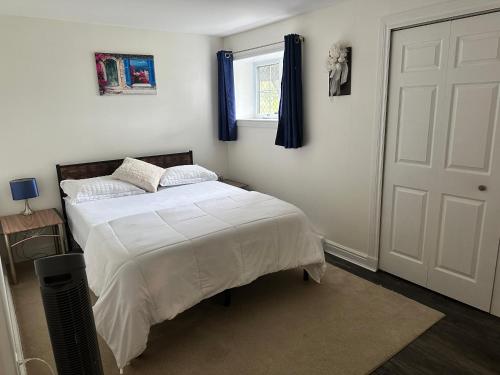 une chambre avec un lit avec des draps blancs et une fenêtre dans l'établissement Central Halifax one Bedroom apartment in Clayton Park, à Halifax