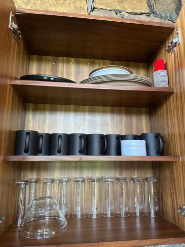 a wooden shelf with glasses and plates and books at Cabaña DAGO in Mazamitla