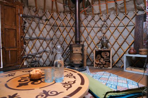 a room with a table with a candle and a stove at Family Eco Farm Getaway in Ryskulovo