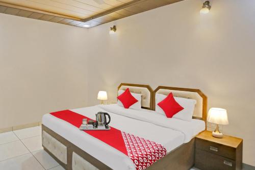 sypialnia z dużym łóżkiem z czerwonymi poduszkami w obiekcie Hotel O THE KNIGHT INN w Nowym Delhi