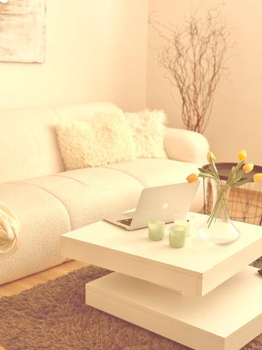 a living room with a couch and a coffee table with a laptop at Trio Apartments in Ostrava