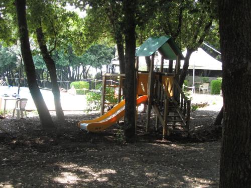 a playground with a slide in a park with trees at illicini in Maratea